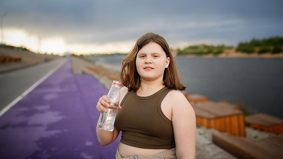 A teen girl out for a walk drinking water